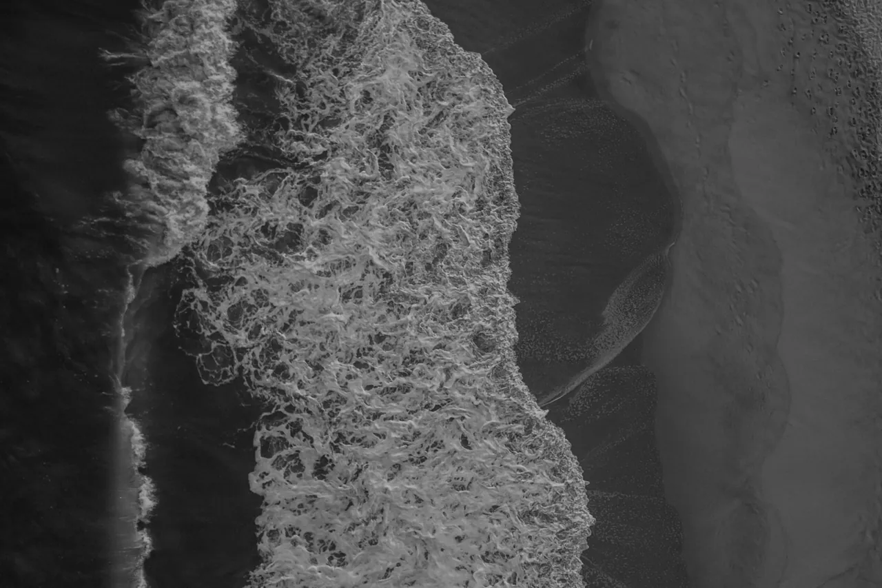 Ocean waves meeting a shoreline viewed from above